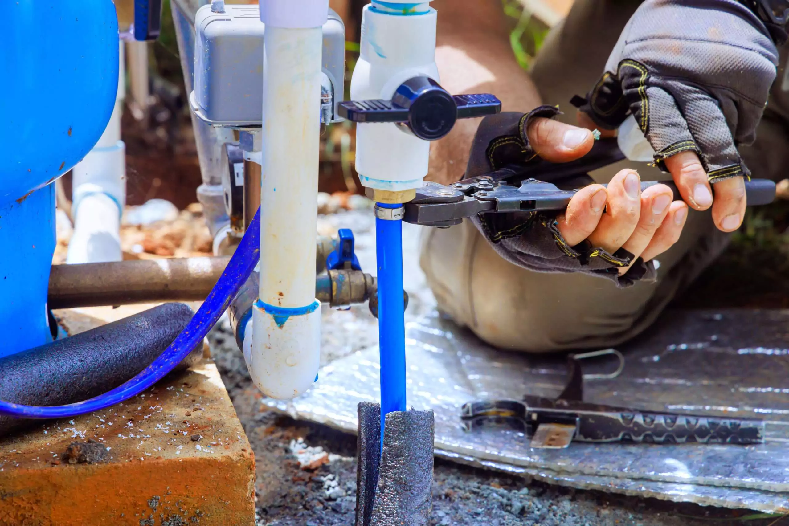 Plumber connecting a PVC water supply pipe during a leak repair