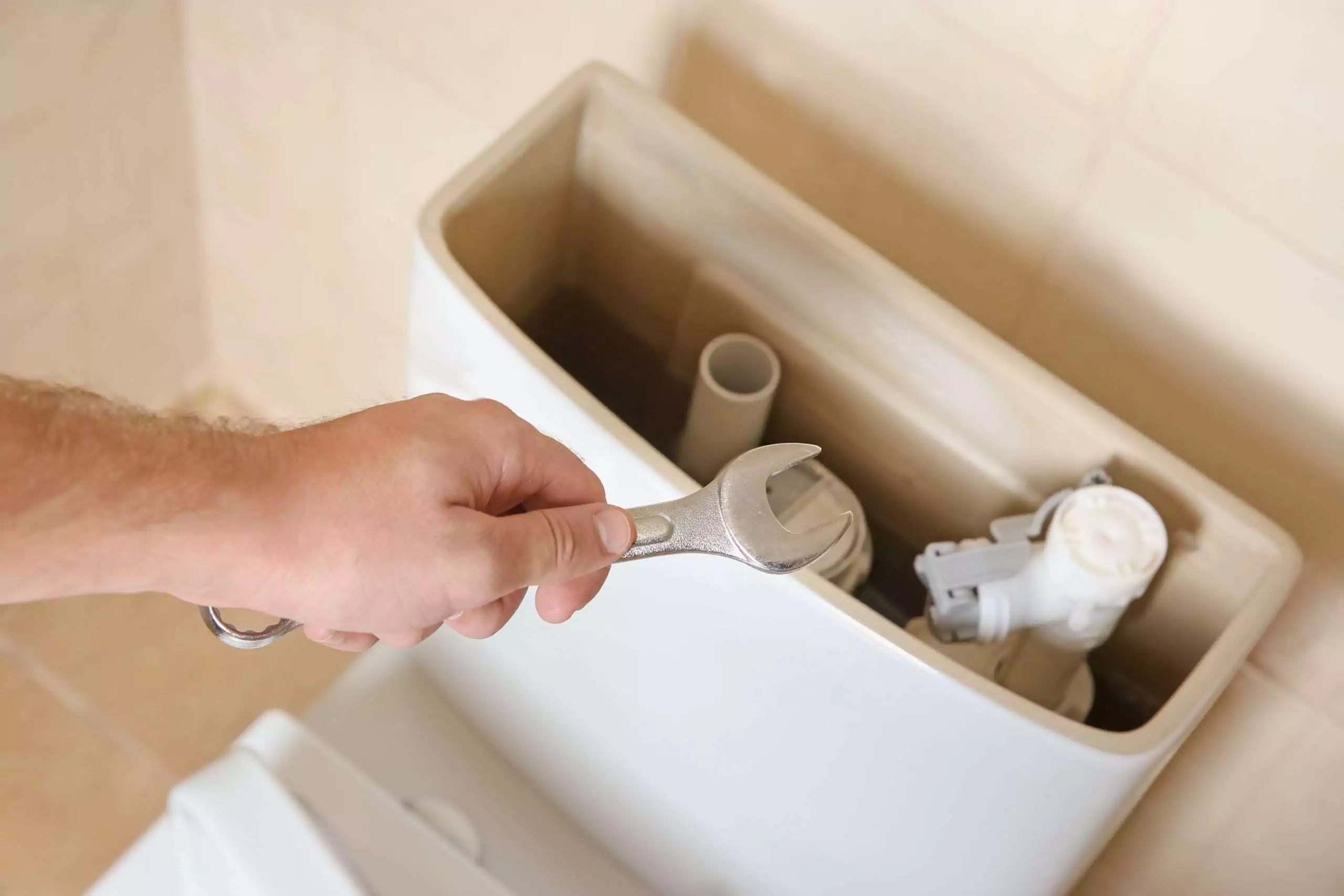 Plumbing Repair: Hand Tightening Toilet Part with Wrench