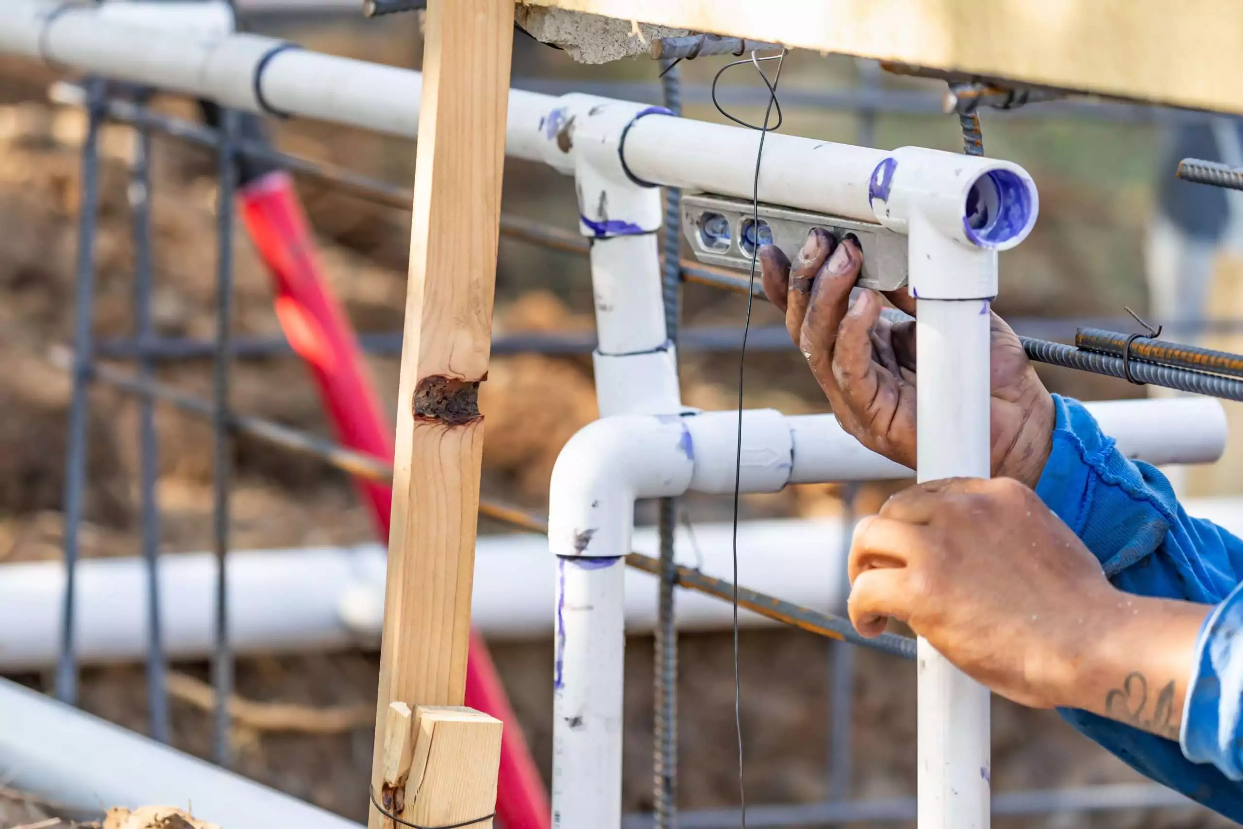 Worker connecting pipes on construction site