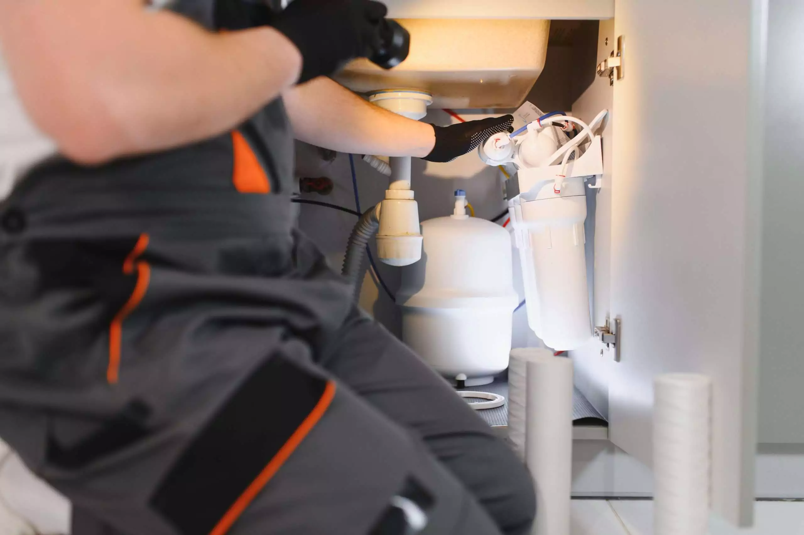 Professional Plumber Installing a Water Filtration System Under a Sink