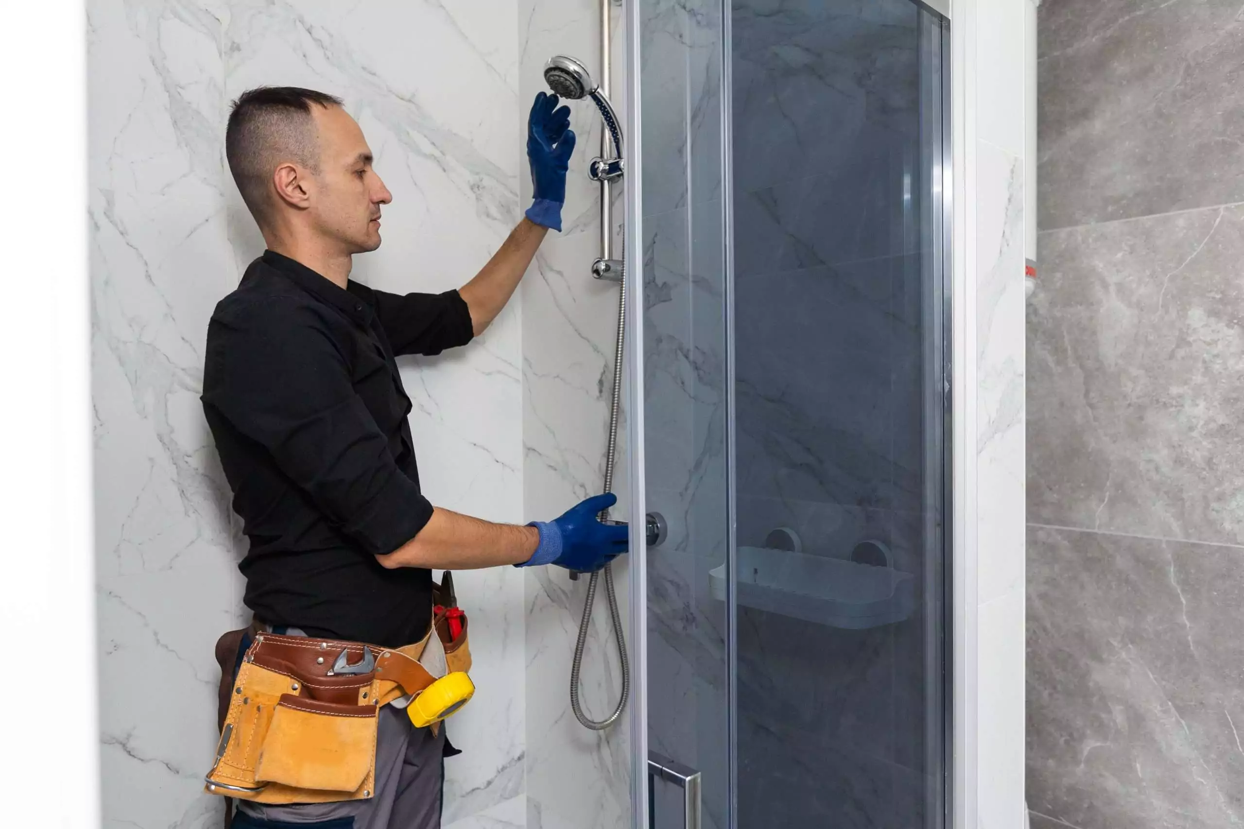 Professional handyman working in shower booth indoors