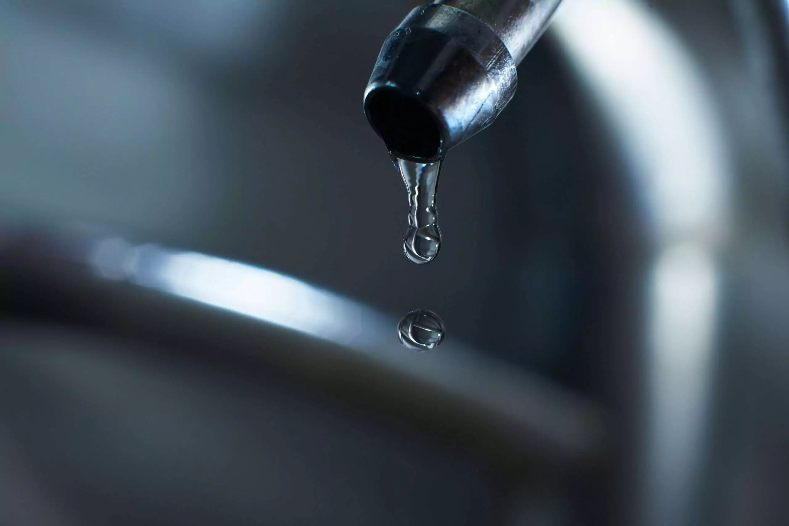 Water Drop Hanging From Metal Faucet Still Life