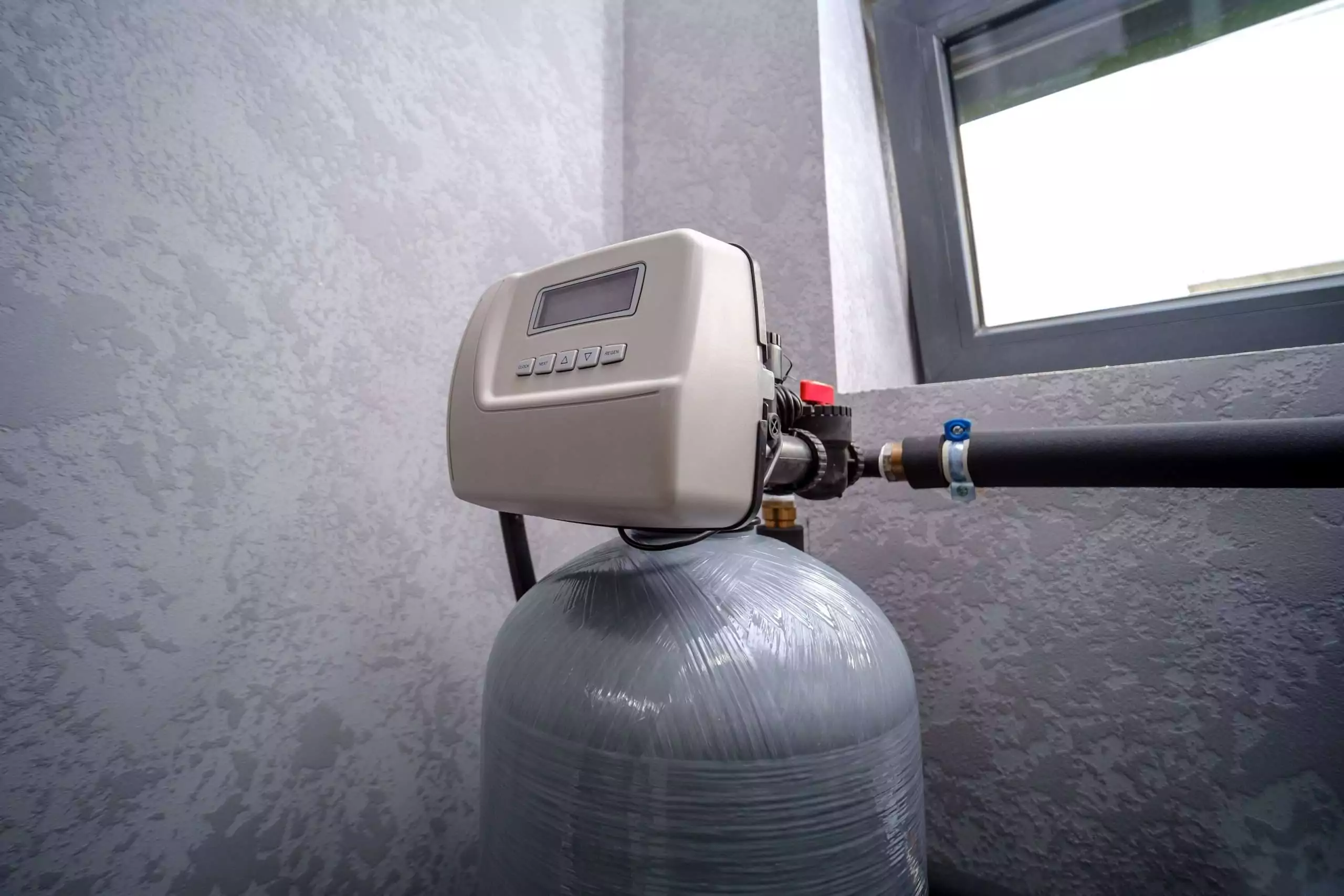 Water Softener System Attached to Pipes Inside Home