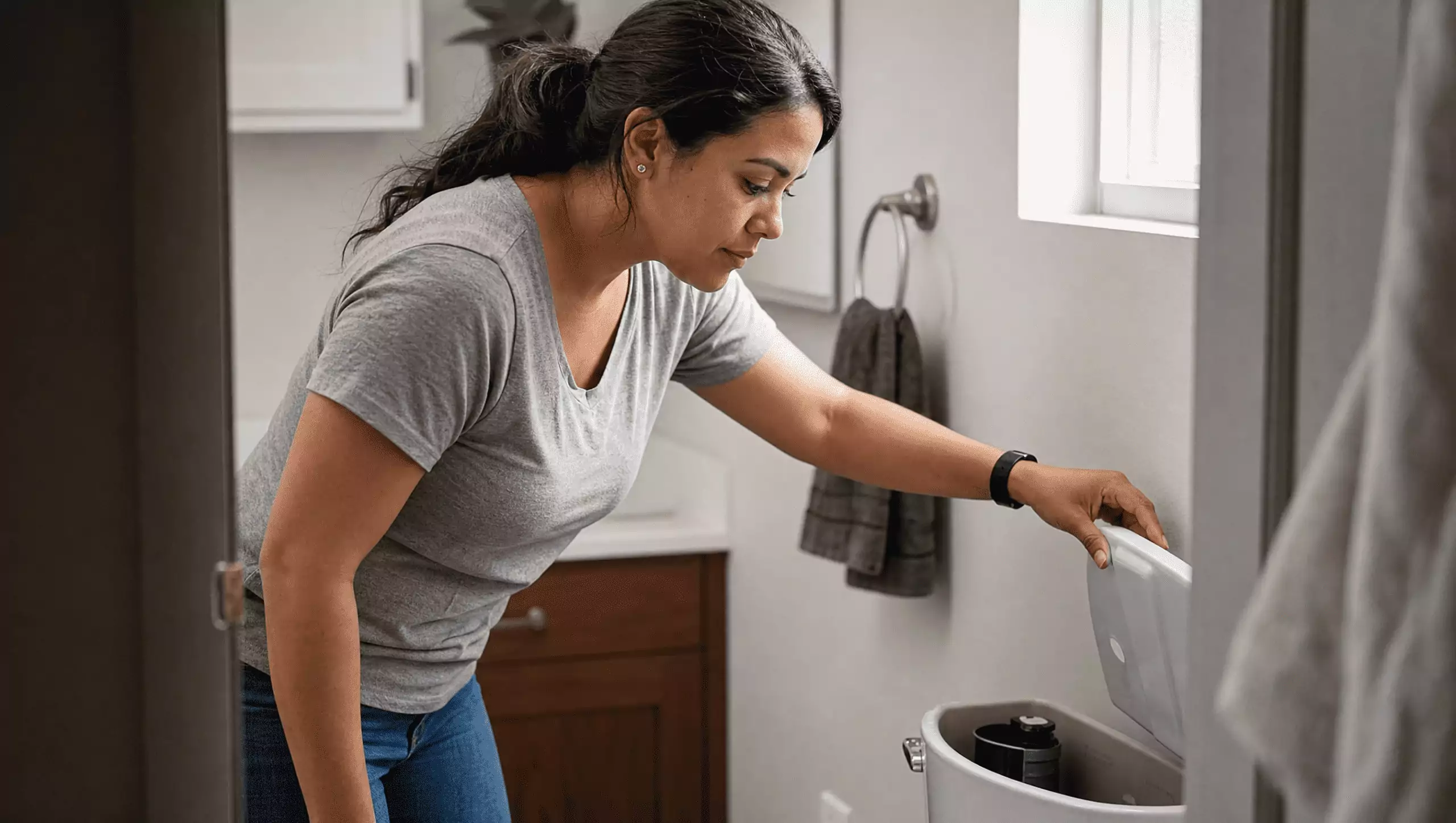woman checking toilet for issues